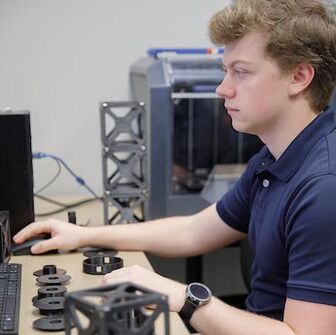 A UASpace student works on modeling a CubeSat using 3D-printed objects.
